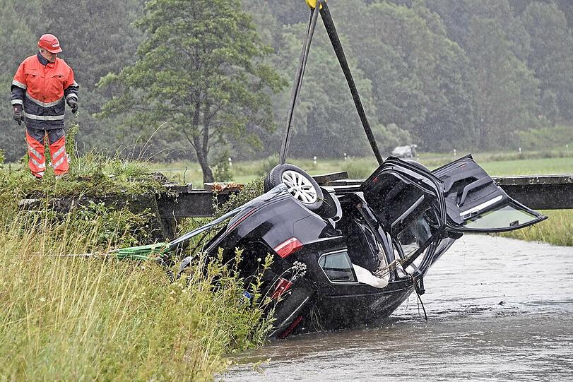 Bei Bayerischzell am Schliersee landet ein Passat kopfüber in einem stark überfluteten Bach. Der Fahrer kann in letzter Sekunde gerettet werden. Die Bilder des Unfalls.