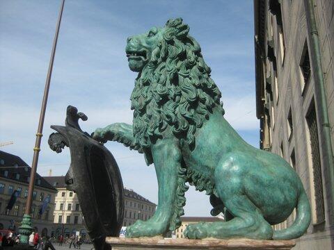 Die Bronzelöwen in der Residenzstraße repräsentieren die Kardinaltugenden Klugheit, Gerechtigkeit, Mäßigung und Tapferkeit. Sie wurden 1595 geschaffen. Ihnen über die blanke Schnauze zu streifen, soll Glück bringen.