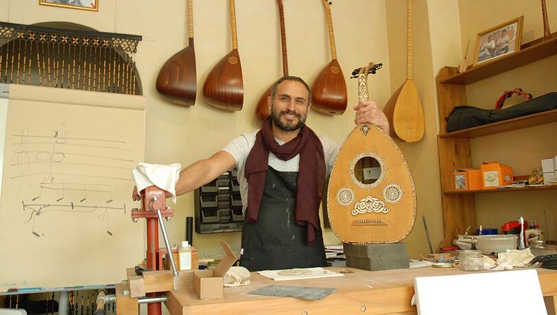 Instrumentenbauer Ali Akbulut in seinem Lauten-Geschäft an der Dachauer Straße, mit einer Ud. Instrumentenbauer Ali Akbulut in seinem Lauten-Geschäft an der Dachauer Straße, mit einer Ud.