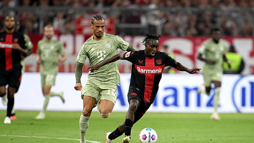 Jeremie Frimpong (r.) im Duell mit Leroy Sané - den Leverkusener Wirbelwind müssen die Bayern laut Broich in den Griff bekommen.