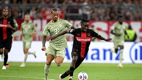 Jeremie Frimpong (r.) im Duell mit Leroy Sané - den Leverkusener Wirbelwind müssen die Bayern laut Broich in den Griff bekommen.