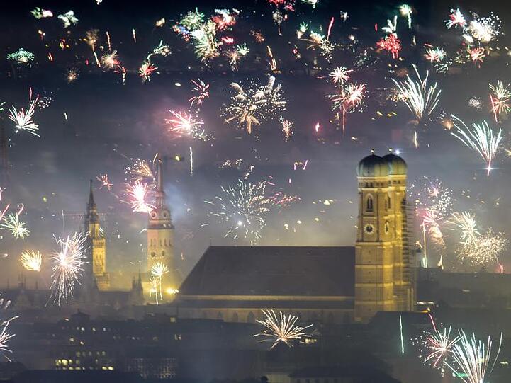 Feuerwerksraketen explodieren in der Silvesternacht über der Frauenkirche. Foto: Matthias Balk/dpa/Archivbild