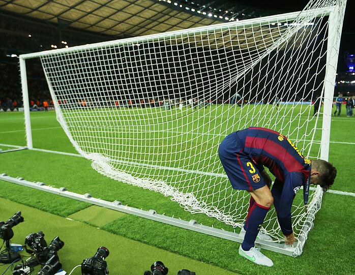 Gerard Piqué sichert sich ein Stück vom Tornetz aus dem Berliner Olympiastadion.