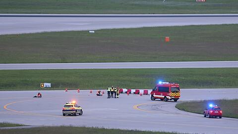 Einsatzkräfte von Polizei und Feuerwehr stehen am Samstag auf einer Startbahn des Flughafens.