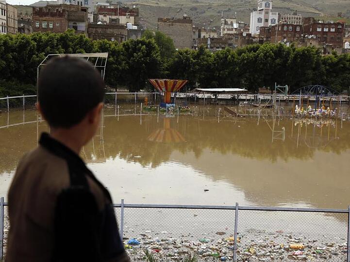 Ein Kind blickt auf einen überschwemmten Vergnügungspark in Sanaa.