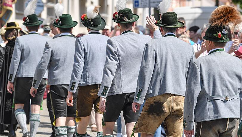 Männer in Lederhosen nehmen am Trachtenumzug teil.