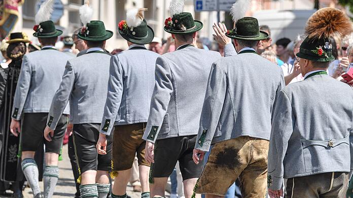 Männer in Lederhosen nehmen am Trachtenumzug teil.