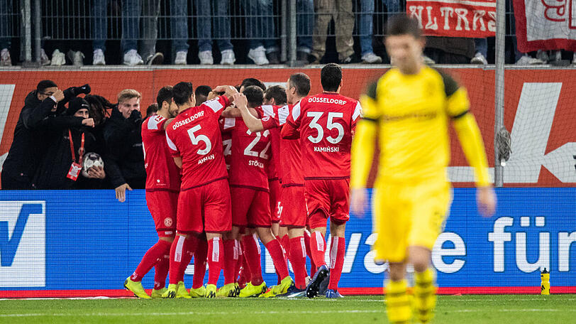 Die Düsseldorfer Spieler (hinten) freuen sich über den Treffer zum 2:0 gegen Herbstmeister Dortmund.