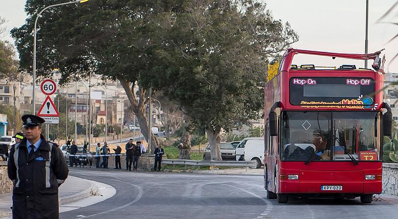 Polizisten stehen an der unfallstelle eines offnenen Doppeldeckerbuses. Der Touristenbus ist gegen tief hängenden Baumästen des auf der linken Seite stehenden Baumes gefahren. Bei dem Unfall des Cabrio-Doppeldeckerbus sind zwei Touristen ums Leben gekommen.