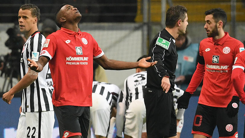 Der Mainzer Jhon Cordoba (Zweiter von links) steht nach seiner Roten Karte mit ausgebreiteten Armen auf dem Platz, während Mitspieler Yunus Malli (rechts) mit Schiedsrichter Gpnter Perl diskutiert.