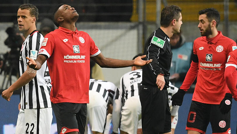 Der Mainzer Jhon Cordoba (Zweiter von links) steht nach seiner Roten Karte mit ausgebreiteten Armen auf dem Platz, während Mitspieler Yunus Malli (rechts) mit Schiedsrichter Gpnter Perl diskutiert. Der Mainzer Jhon Cordoba (Zweiter von links) steht nach seiner Roten Karte mit ausgebreiteten Armen auf dem Platz, während Mitspieler Yunus Malli (rechts) mit Schiedsrichter Gpnter Perl diskutiert.