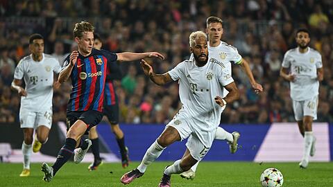 Münchens Eric Maxim Choupo-Moting (r) und Barcelonas Frenkie de Jong kämpfen um den Ball.