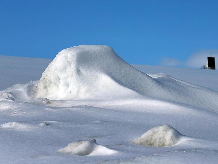 Der Kirchturm von Huttenwang ragt aus der mit Neuschnee bedeckten Landschaft. Foto: Karl-Josef Hildenbrand