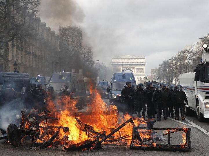 Eine Barrikade brennt bei "Gelbwesten"-Protesten auf den Champs-Élysées. Polizei.