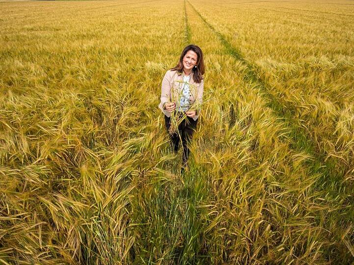 Michaela Kaniber (CSU) steht in einem Feld mit Wintergerste. Foto: Peter Kneffel/dpa