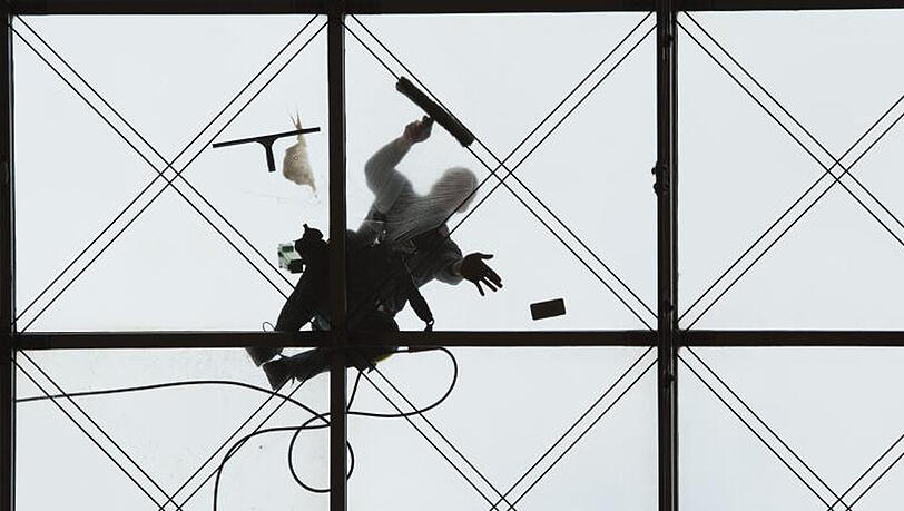 Zwei Gebäudereiniger putzen in Dresden das gewölbte Glasdach des World Trade Centers. Zwei Gebäudereiniger putzen in Dresden das gewölbte Glasdach des World Trade Centers.