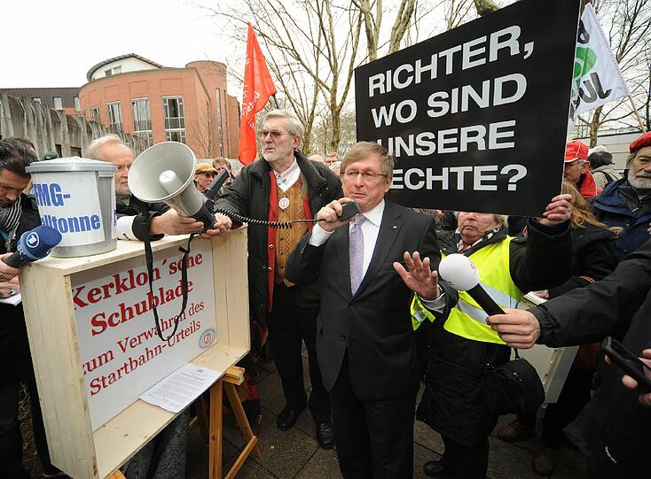 Während im Gericht das Urteil verkündet wird, demonstrieren die Startbahn-Gegner vor dem Gebäude mit Plakaten, Trillerpfeifen und Sprechchören weiter.