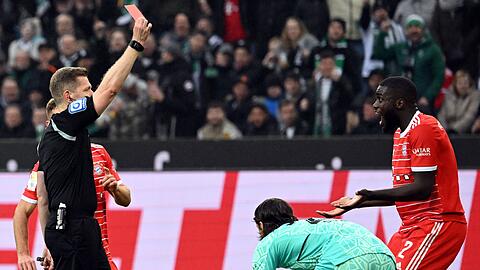 Schiedsrichter Tobias Welz zeigt Bayerns Dayot Upamecano (r) die rote Karte.