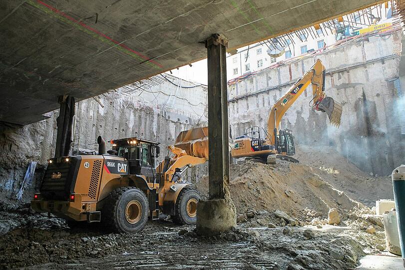 Mit schwerem Gerät wird das Erdreich aus dem untersten Stockwerk ausgebaggert.