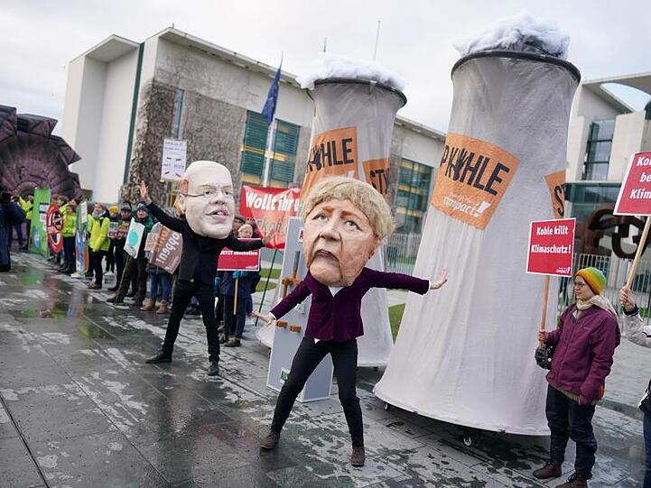 Aktivisten protestieren verkleidet als Angela Merkel und Peter Altmaier vor dem Bundeskanzleramt gegen den Zeitplan für den Kohleausstieg.