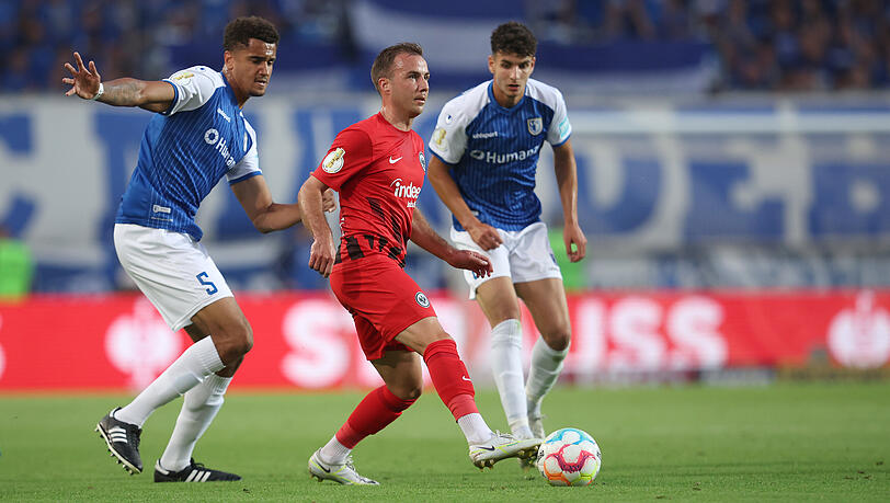 Pflichtspiel-Debüt im DFB-Pokal: Der Neu-Frankfurter Mario Götze (Mitte) wird von den Magdeburgern Jamie Lawrence (links) und Daniel Elfadli bedrängt. Pflichtspiel-Debüt im DFB-Pokal: Der Neu-Frankfurter Mario Götze (Mitte) wird von den Magdeburgern Jamie Lawrence (links) und Daniel Elfadli bedrängt.