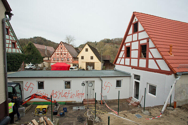 Der Schriftzug «Kein Asylat (Asylant) in Vorra» und Hakenkreuze sind am 12.12.2014 in Vorra (Bayern) an einer Hauswand zu lesen. In der Nacht hatten im Ortskern des Dorfes im Kreis Nürnberger Land ein ehemaliger Gasthof, ein nahe gelegenes Wohnhaus sowie eine Scheune gebrannt. In die Gebäude sollten in der kommenden Woche Asylbewerber einziehen.