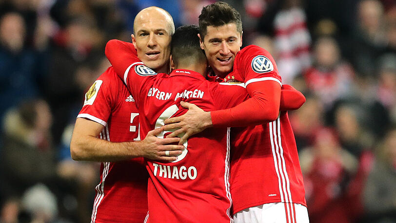 Arjen Robben und Robert Lewandowski (rechts) herzen den Torschützen Thiago (Mitte).
