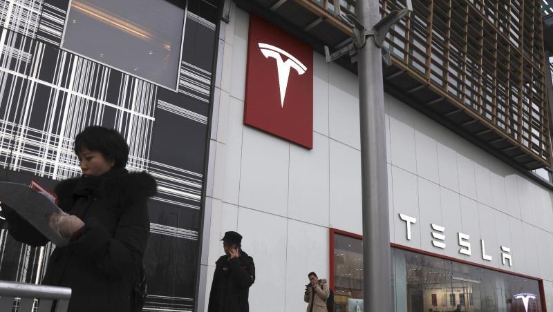 Fußgänger gehen an einer Tesla-Filiale in Peking vorbei. Fußgänger gehen an einer Tesla-Filiale in Peking vorbei.