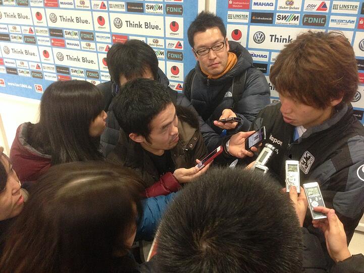 Yuya Osako umringt von japanischen Journalisten.