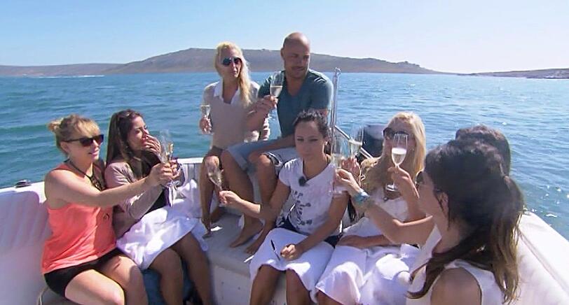 Christian genießt zusammen mit Lisa, Ela, Susi, Maggie, Helen, Anne und Nadja (v.l.n.r.) das Gruppendate auf einem Boot.
