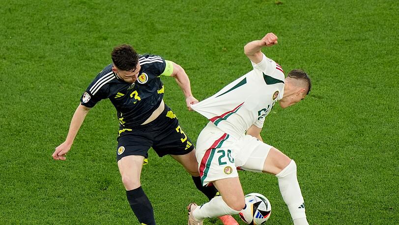 Die Ungarn um Roland Sallai (r) holten gegen Andrew Robertson und Schottland einen späten Sieg.