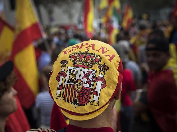Ein Mann mit einer Mütze auf der das spanische Wappen zu sehen ist, nimmt an einer Demonstration, die während des Nationalfeiertags in Spanien stattfindet, teil.