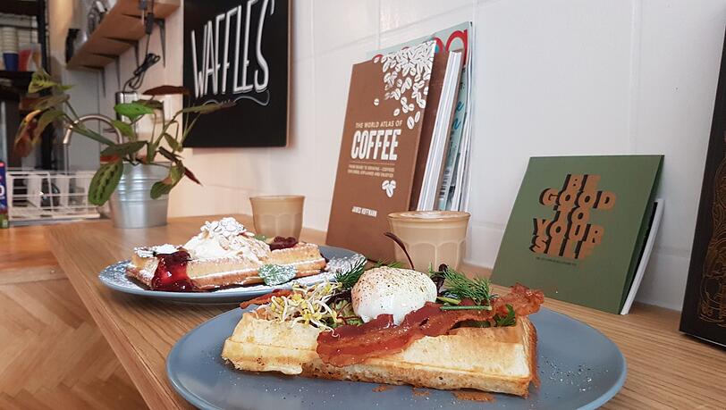 Vorne eine Waffel mit Ei, Avocado und Speck, hinten ist’s süß. Vorne eine Waffel mit Ei, Avocado und Speck, hinten ist’s süß.