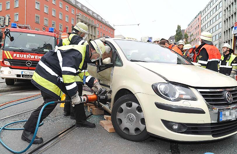 Mit schwerem Gerät schneidet die Feuerwehr die Tür des VW auf...