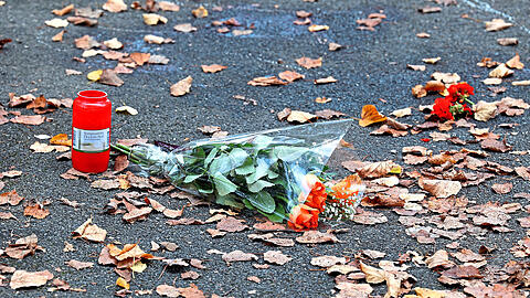 Blumen und Kerzen liegen an der Stelle in der Grünanlage, an der der 25-Jährige in der Nacht auf Sonntag tot aufgefunden wurde.