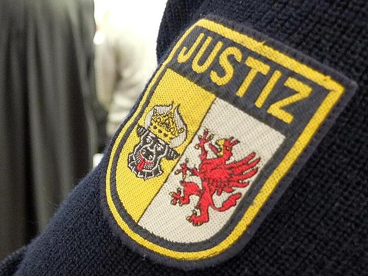 Ein Justizbeamter steht im Sitzungssaal. Foto: Marcus Brandt/dpa/Archivbild