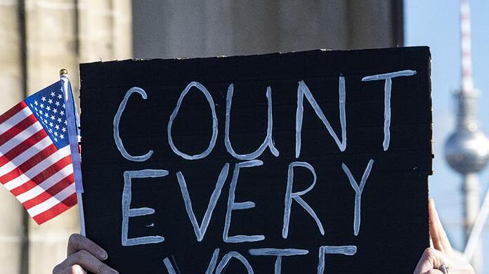 Ein Schild mit der Aufschrift "Count Every Vote" und eine Mini-US-Flagge bei einer Kundgebung in Berlin. In den USA waren mehr als 200 Millionen Amerikaner aufgerufen, einen neuen Präsidenten und die Abgeordneten des Repräsentantenhauses zu wählen.