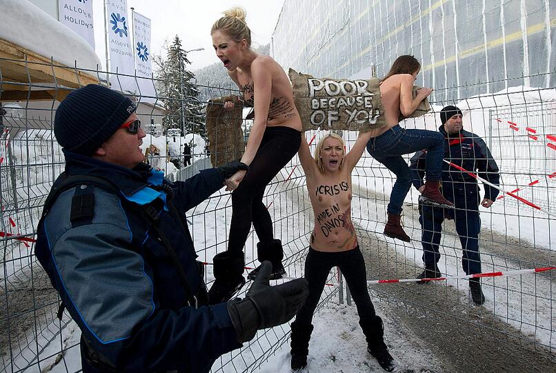 Nacktprotest in Davos: Ukrainerinnen demonstrieren barbusig am Zaun vor dem Weltwirtschaftsforum. Die Polizei greift ein - die Bilder.
