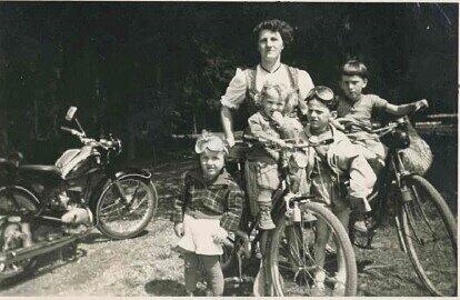 1956: Familienausflug mit Radl und Motorrad. Die Leserin ist in der Mitte auf dem Kindersitz zu sehen. Kinderanhänger gab’s damals noch nicht.