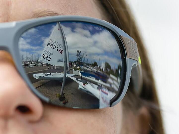 Das Segel eines Bootes spiegelt sich in der Sonnenbrille einer Frau. Foto: Frank Molter/Archiv