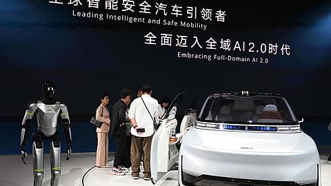Hier pr&auml;sentiert Geely ein Auto samt humanoidem Roboter auf einer Automesse in Peking. Nun wagt die Firma den Sprung nach Spanien, um dort Autos zu bauen.