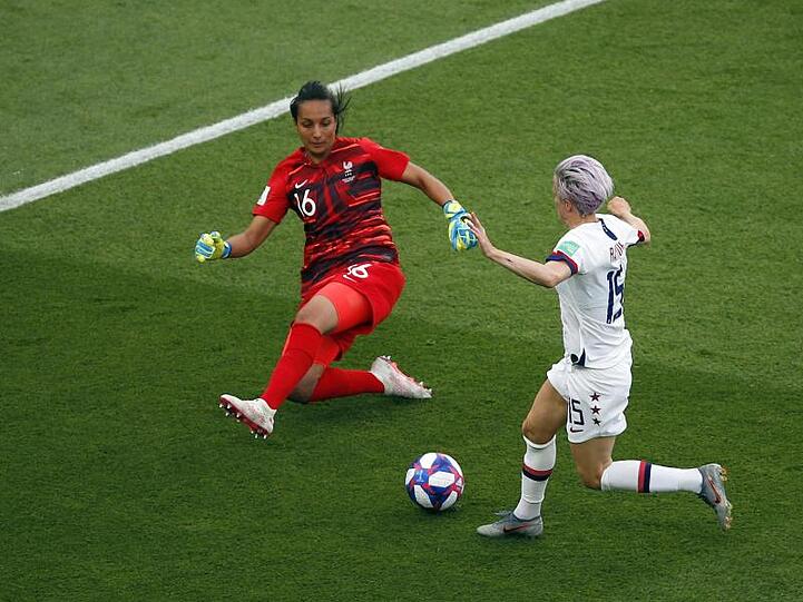 Frankreichs Torhüterin Sarah Bouhaddi (l) ist aus dem Tor gelaufen und kommt vor Megan Rapinoe an den Ball.