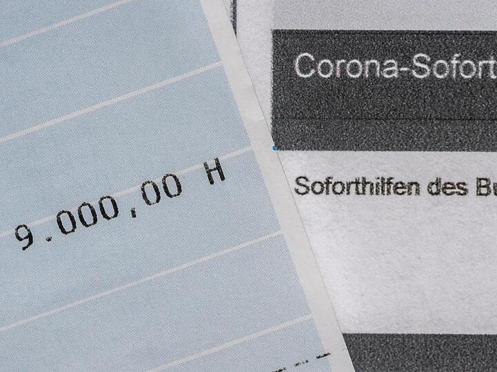Ein Kontoauszug mit der überwiesenen Summe von 9.000 Euro Corona-Soforthilfe liegt auf einem Antrag für den Zuschuss der Sächsischen Aufbaubank.
