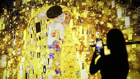 Die immersive Show "Klimts Kuss" bietet eine Reise durch das Wien um 1900, die Malerei des Jugendstilkünstlers löst sich freilich in ihre schimmernden Partikel auf.