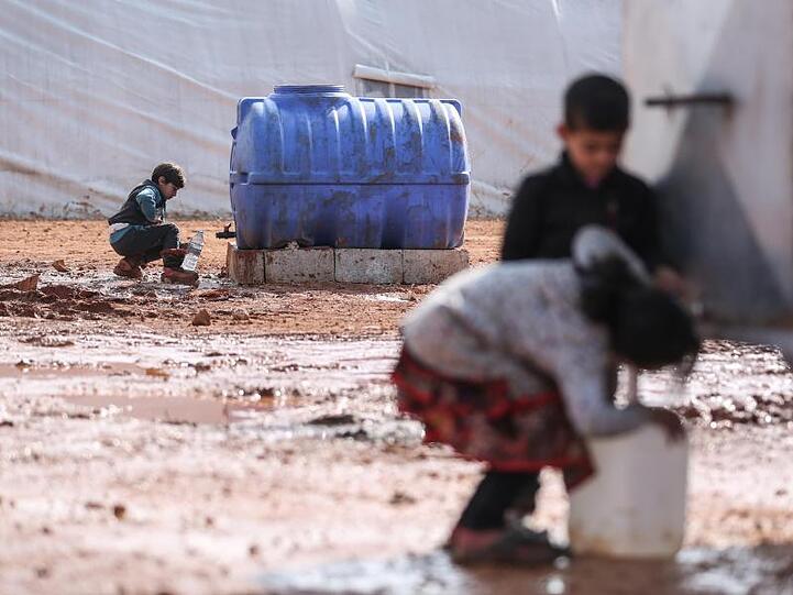 Kinder füllen in einem provisorischen Lager in der Region Idlib Behälter mit Wasser auf. Von den Hilfsgütern, die bisher die Grenzübergänge passierten, sind westlichen Angaben zufolge etwa 2,8 Millionen Menschen abhängig.