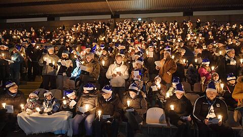 Stimmungsvolle Atmosphäre: Mit Kerzen in den Händen singen die 1860-Fans zusammen Weihnachtslieder. (Archiv)