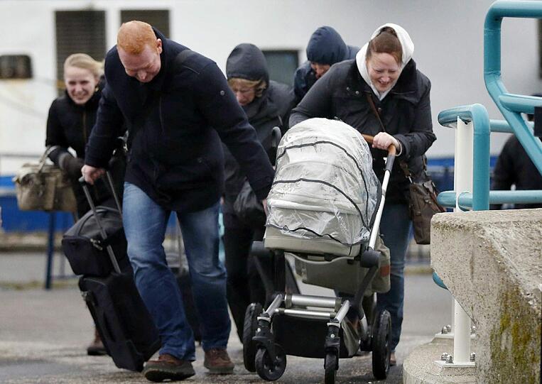 Eine Familie kämpft mit Kinderwagen gegen Sturmtief Xaver an