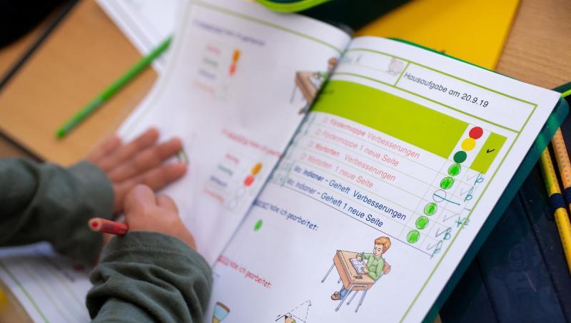 Ein Schulkind einer 2. Klasse arbeitet mit einem Schulbuch.