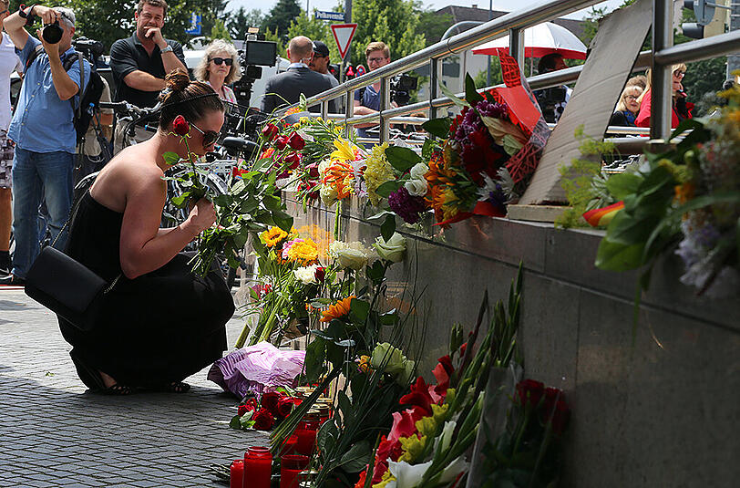 Eine Frau legt Blumen nieder &ndash; einen Tag nach dem Amoklauf.