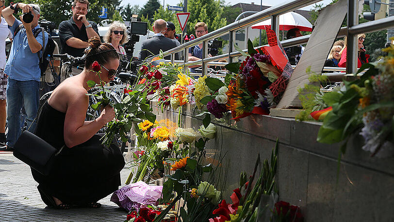 Eine Frau legt Blumen nieder – einen Tag nach dem Amoklauf. Eine Frau legt Blumen nieder – einen Tag nach dem Amoklauf.